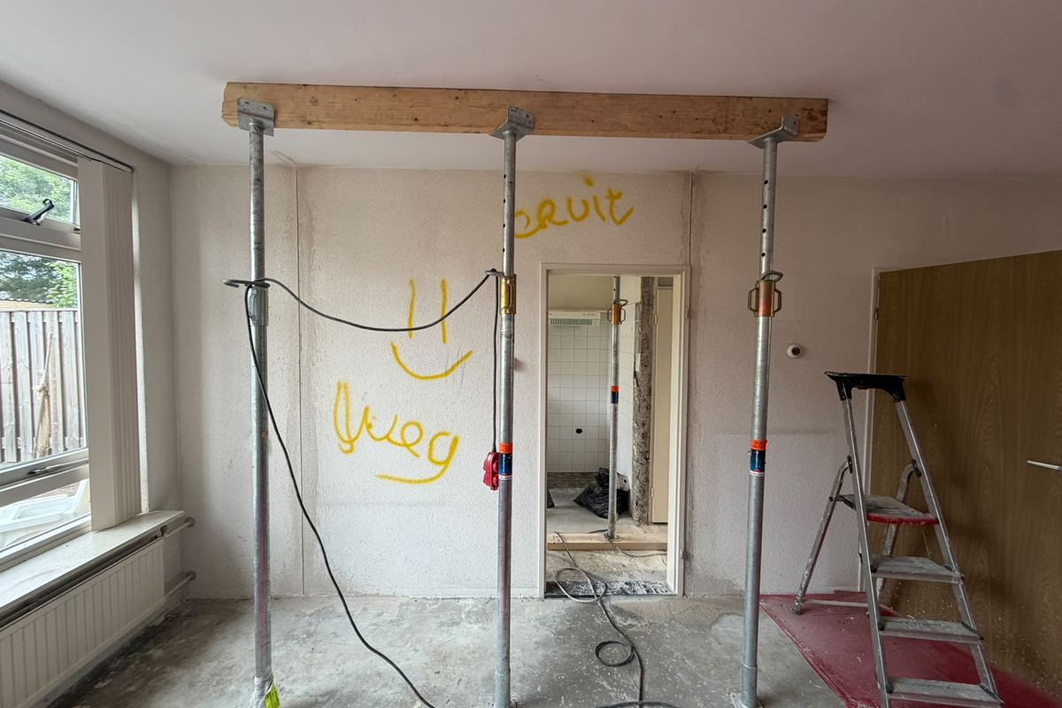Dezelfde wand afgetekend met de tekst eruit, met stempels en een houten kesp tegen het plafond